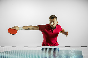 Image showing Young man playing table tennis on white studio background