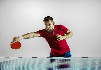 Image showing Young man playing table tennis on white studio background