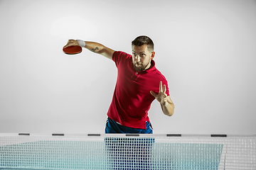 Image showing Young man playing table tennis on white studio background