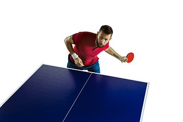 Image showing Young man playing table tennis on white studio background