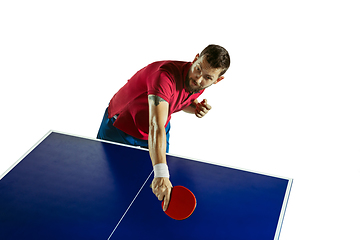 Image showing Young man playing table tennis on white studio background