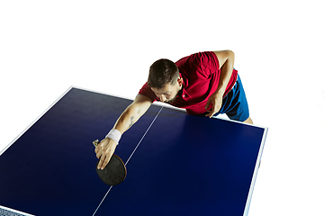 Image showing Young man playing table tennis on white studio background