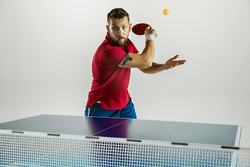 Image showing Young man playing table tennis on white studio background