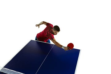 Image showing Young man playing table tennis on white studio background