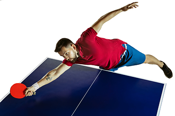 Image showing Young man playing table tennis on white studio background