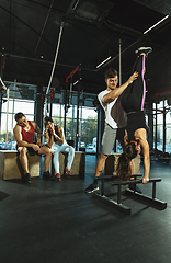 Image showing A group of muscular athletes doing workout at the gym