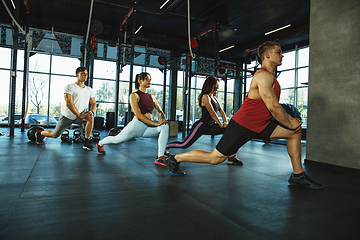 Image showing A group of muscular athletes doing workout at the gym