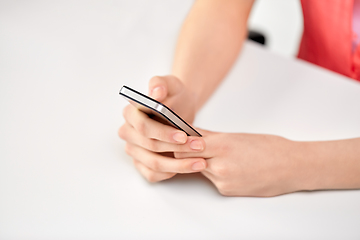 Image showing close up of female hands with smartphone