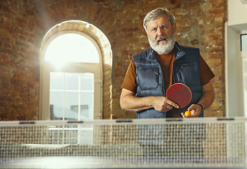 Image showing Senior man playing table tennis in workplace, having fun