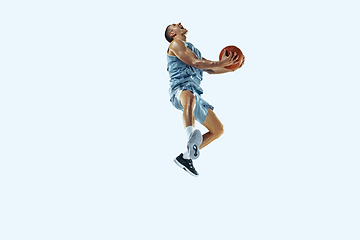 Image showing Young caucasian basketball player against white studio background