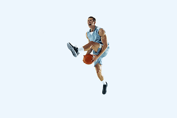 Image showing Young caucasian basketball player against white studio background