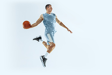 Image showing Young caucasian basketball player against white studio background