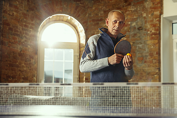 Image showing Senior man playing table tennis in workplace, having fun