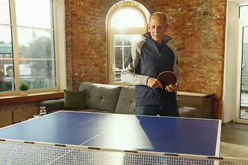 Image showing Senior man playing table tennis in workplace, having fun