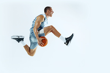 Image showing Young caucasian basketball player against white studio background