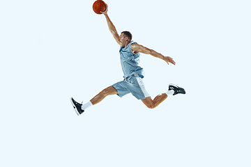 Image showing Young caucasian basketball player against white studio background