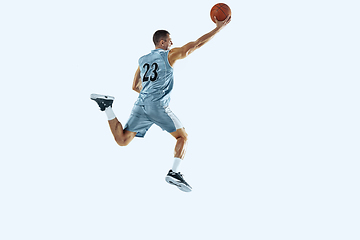 Image showing Young caucasian basketball player against white studio background