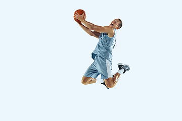 Image showing Young caucasian basketball player against white studio background