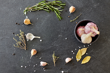 Image showing garlic in bowl and rosemary on stone surface