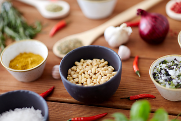 Image showing pine nuts in bowl and spices on kitchen table