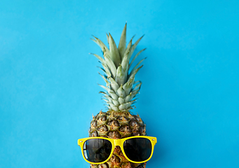 Image showing pineapple in yellow sunglasses on blue background