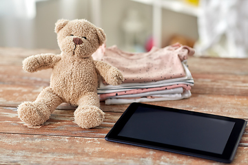 Image showing baby clothes, teddy bear toy and tablet computer
