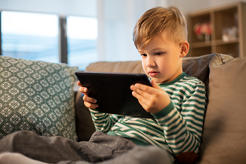 Image showing happy little boy with tablet computer at home