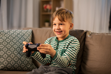 Image showing little boy with gamepad playing video game at home