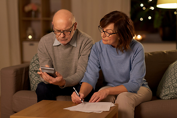 Image showing senior couple with papers and calculator at home