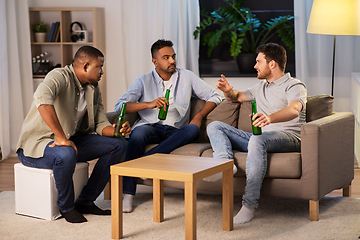 Image showing happy male friends drinking beer at home at night