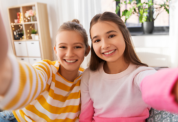 Image showing happy teenage girls taking selfie at home