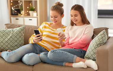 Image showing happy teenage girls with smartphones at home