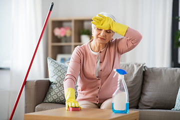 Image showing tired senior woman cleaning table at home