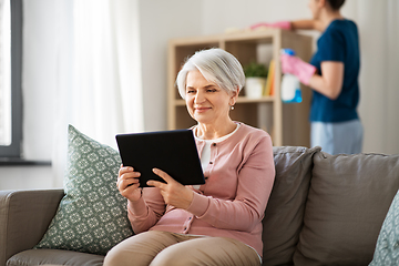 Image showing old woman with tablet pc and housekeeper at home