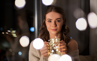 Image showing woman with christmas garland lights in glass mug