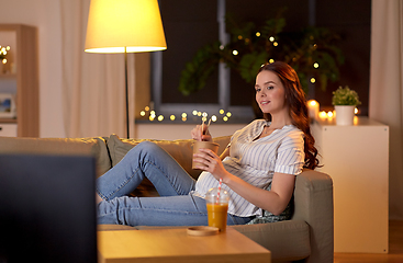 Image showing pregnant woman watching tv and eating wok at home