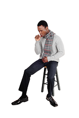 Image showing Coughing young African man sitting on chair