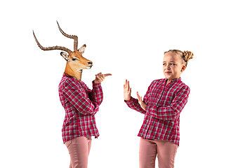 Image showing Young handsome girl arguing with herself as a deer on white studio background.