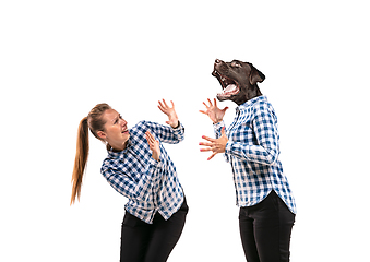 Image showing Young handsome woman arguing with herself as a dog on white studio background.