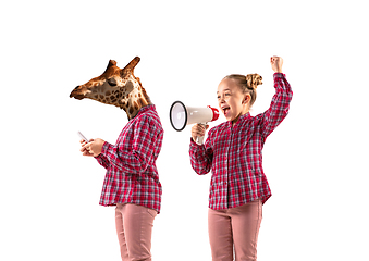 Image showing Young handsome girl arguing with herself as a giraffe on white studio background.