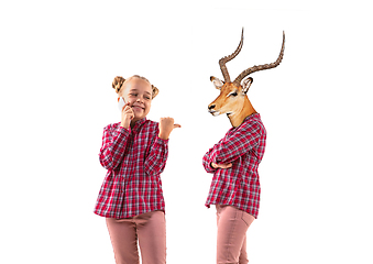 Image showing Young handsome girl arguing with herself as a deer on white studio background.
