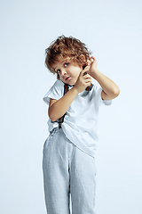 Image showing Pretty young boy in casual clothes on white studio background