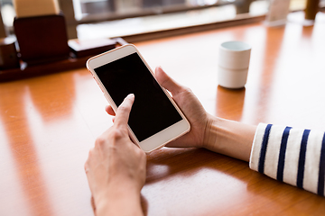 Image showing Woman using cellphone at restaurant