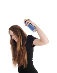 Image showing Woman putting hair spray on her hair