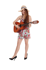 Image showing Woman standing in a dress with her guitar