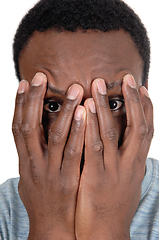 Image showing African man holding his hands over face