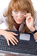 Image showing The tired young woman in glasses sits with the laptop. Isolated