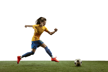 Image showing Female soccer player kicking ball at the stadium