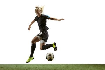 Image showing Female soccer player kicking ball at the stadium