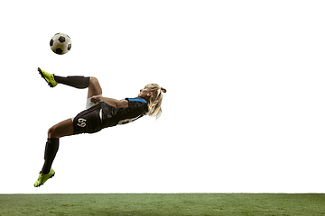 Image showing Female soccer player kicking ball at the stadium